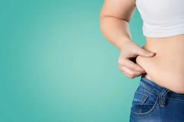 Image of woman pinching her love handles to show weight gain Sussex