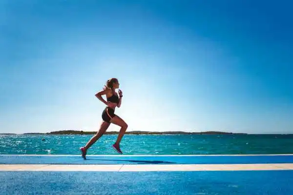 Woman running showing strong leg muscle Sussex